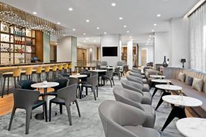 restauracja ze stołami i krzesłami oraz bar w obiekcie AC Hotel Park City w mieście Park City