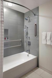 een badkamer met een douche en een bad bij Augusta Marriott at the Convention Center in Augusta