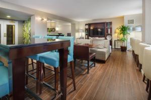 a living room with a bar and a dining room at Augusta Marriott at the Convention Center in Augusta