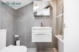 La salle de bains est pourvue de toilettes blanches et d'un lavabo. dans l'établissement HAML Heliodoor Apartments Milton Keynes, Free Parking, Free WiFi & Movies, 7-min drive to City Centre, à Wolverton