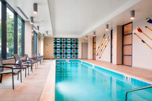 una piscina en un hotel con sillas alrededor en Residence Inn by Marriott Boston Watertown, en Watertown