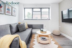 - un salon avec un canapé gris et une table dans l'établissement HAML Heliodoor Apartments Milton Keynes, Free Parking, Free WiFi & Movies, 7-min drive to City Centre, à Wolverton