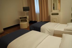 a hotel room with two beds and a television at Residence Prestige in Gorgonzola