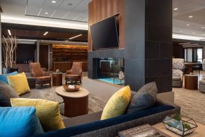 a lobby with a blue couch and a tv at Courtyard by Marriott Loveland Fort Collins in Loveland