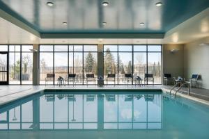 a swimming pool with tables and chairs in a building at Courtyard by Marriott Loveland Fort Collins in Loveland