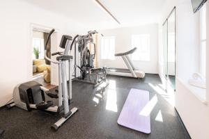 a gym with treadmills and machines in a room at Ferienwohnung Hindenburg in Saalfelden am Steinernen Meer