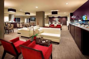 a living room with a white couch and red chairs at San Mateo Marriott San Francisco Airport in San Mateo