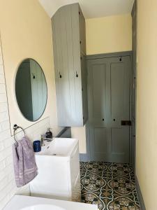 a white bathroom with a sink and a mirror at Cosy cottage in the heart of Bakewell in Bakewell