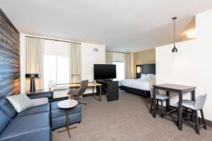 Residence Inn by Marriott Indianapolis South/Greenwood في انديانابوليس: غرفة في الفندق مع أريكة وسرير