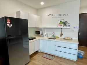 a kitchen with white cabinets and a black refrigerator at HolidayCozy StraitsGardenSuite Penang#6pax#family in George Town