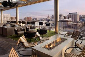 a patio with chairs and a fire pit on a roof at AC Hotel by Marriott Austin-University in Austin