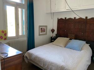 Schlafzimmer mit einem Bett, einem Schreibtisch und einem Fenster in der Unterkunft Villa avec piscine en plein cœur de ville in Montpellier