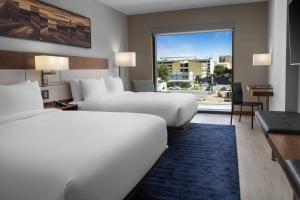 a hotel room with two beds and a large window at AC Hotel by Marriott Austin-University in Austin