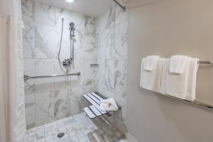 a white bathroom with a shower and a toilet at Castle Hotel, Autograph Collection by Marriott in Orlando