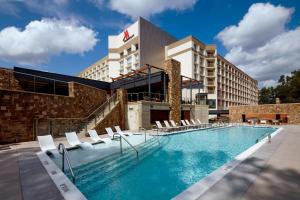 een hotelzwembad met stoelen voor een gebouw bij Raleigh Marriott Crabtree Valley in Raleigh