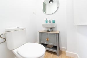 a bathroom with a white toilet and a sink at Piso Estrella 031 in Torre del Mar +20 photos