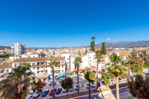 a city with cars parked in a parking lot with palm trees at Piso Estrella 031 in Torre del Mar