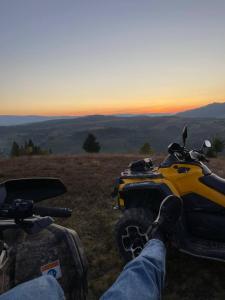 een persoon met zijn voeten op een atv in een veld bij Карпатська садиба in Plavie