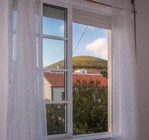 an open window with a view of a mountain at Porto Martins Bay Apartments AL in Porto Martins