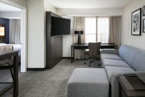 a hotel room with a couch and a desk at Residence Inn by Marriott Tulsa South in Tulsa