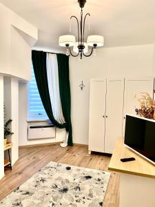 a living room with a chandelier and a large window at GREEN Apartment in Riga