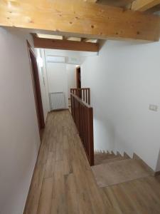 una stanza vuota con scale e soffitti in legno di Borgo Sciugolo a Baselice