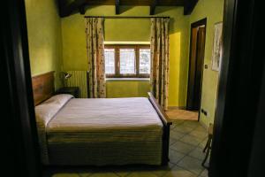 Schlafzimmer mit einem Bett und einem Fenster in der Unterkunft Cadgal - Tenuta Valdivilla in Santo Stefano Belbo