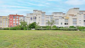 un grande edificio con un prato davanti di Residence de la Plage- 217-Appart vue mer- 10 pers a Cap d'Agde