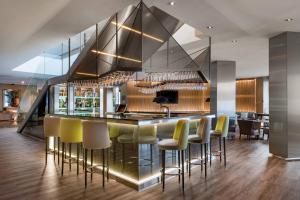 a kitchen with a bar with yellow bar stools at AC Hotel Milano by Marriott in Milan