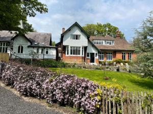 a house with purple flowers in front of a fence at The Woodlands in Sandsend