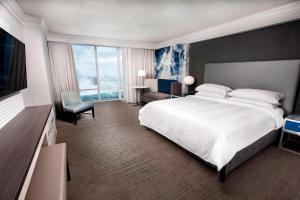 a hotel room with a large bed and a large window at Niagara Falls Marriott on the Falls in Niagara Falls
