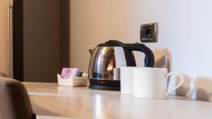 a tea kettle and a cup on a table at Albergo Casavecchia in Tiarno di Sopra