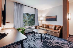 a hotel room with a couch and a table at Fairfield Inn & Suites by Marriott Tulsa Catoosa in Catoosa