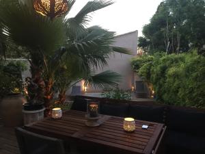 una mesa de madera con velas en el patio en Villa avec piscine en plein cœur de ville en Montpellier