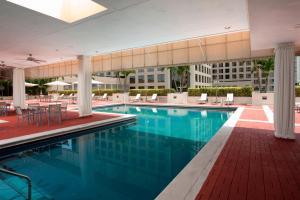 a swimming pool in a hotel with tables and chairs at Miami Marriott Dadeland in Miami