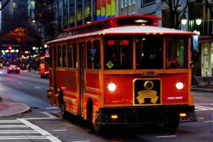 a red trolley car driving down a city street at The Ritz-Carlton, Charlotte in Charlotte