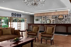 uma sala de estar com cadeiras, uma mesa e um lustre em Irene Country Lodge, Autograph Collection em Centurion