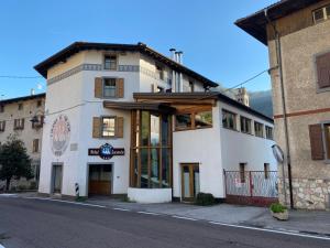 duży biały budynek po stronie ulicy w obiekcie Hotel Bed & Bike Ledro w mieście Molina di Ledro