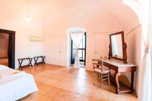 a bedroom with a desk and a mirror and a bed at Masseria Spina Resort in Monopoli