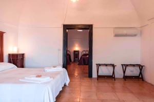 a bedroom with two beds with white sheets and a doorway at Masseria Spina Resort in Monopoli