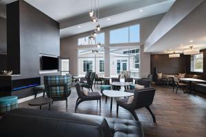 un vestíbulo con mesas, sillas y TV en Residence Inn New Brunswick Tower Center Blvd. en East Brunswick