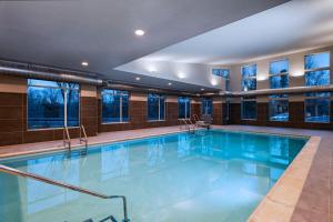 a large swimming pool in a building with windows at Residence Inn New Brunswick Tower Center Blvd. in East Brunswick