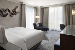 Habitación de hotel con cama blanca y silla en The Westin Palo Alto en Palo Alto