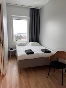 a bedroom with a bed with a window and a chair at City Apartment with lake view and free parking in Kuopio +14 photos