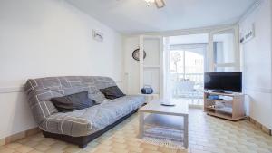 een woonkamer met een bank en een tv bij Le Cosmos - 15C - Appart spacieux- 4 pers in Cap d'Agde