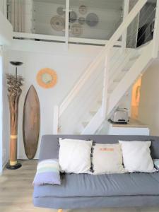 salon z niebieską kanapą i schodami w obiekcie Archipel II- 30C - Appart moderne - 6 pers w Cap d'Agde