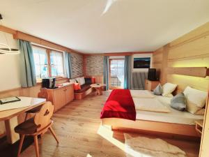 a bedroom with a large bed and a desk and a table at Appartements Luttinger in Biberwier