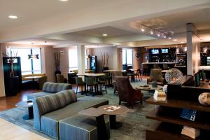 a living room with a couch and chairs and tables at Courtyard Shreveport Airport in Shreveport