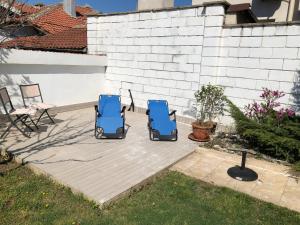 two blue chairs sitting on a backyard patio at Морска Роза in Sinemorets