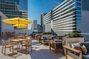 a patio with tables and chairs and umbrellas at The Westin Houston Medical Center - Museum District in Houston